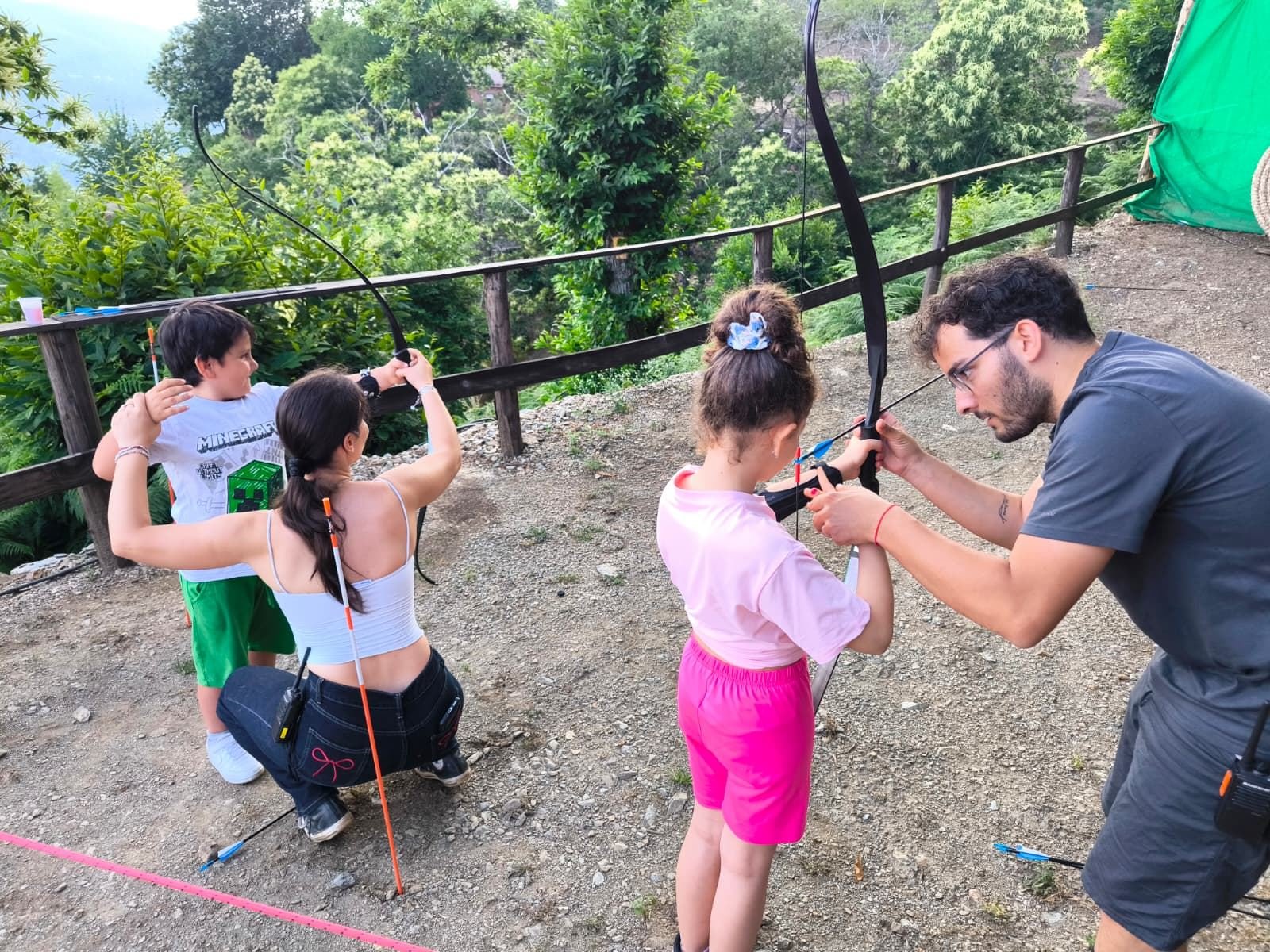 Bambini provano il tiro con l'arco durante un compleanno